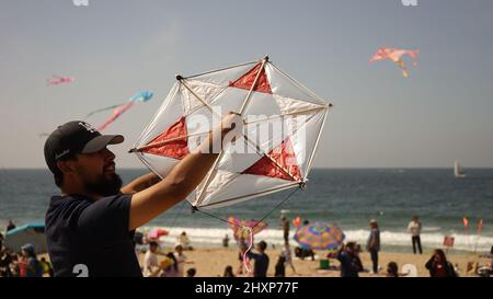 Los Angeles, California, USA. 13th Mar, 2022. A man flies a kite at the Redondo Beach in Los Angeles, California, the United States on March 13, 2022. Thousands of people on Sunday gathered at the Redondo Beach Pier in Los Angeles for its 48th Annual Festival of the Kite. Credit: Zeng Hui/Xinhua/Alamy Live News Stock Photo