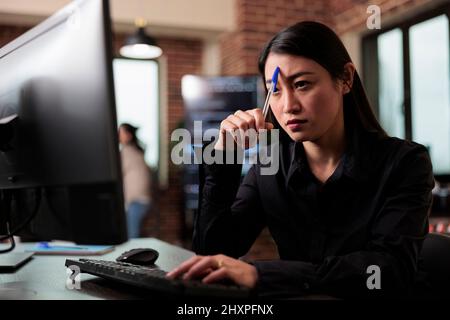 Pensive network engineer reflecting at failed data processing operation and security system unknown breach. Thoughtful software developer thinking of ways to upgrade encryption program. Stock Photo