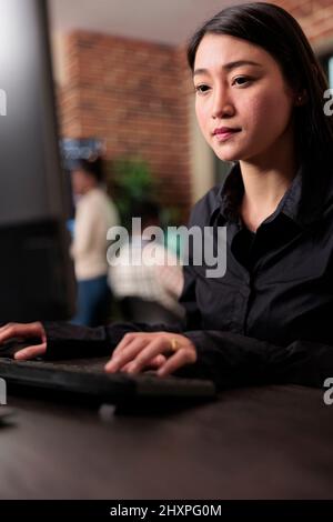 Asian system administrator upgrading firewall system in order to maintain security stability. Application developer encrypting cloud storage database by updating network algorithm. Stock Photo