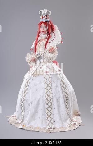 Queen wizard. Model dressed in renaissance style on gray background Stock Photo