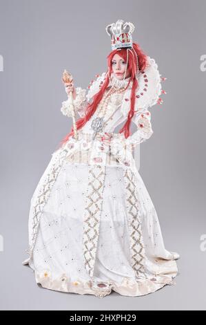 Queen wizard. Model dressed in renaissance style on gray background Stock Photo