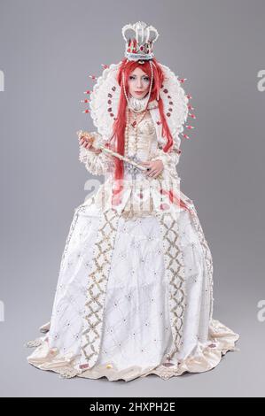 Queen wizard. Model dressed in renaissance style on gray background Stock Photo