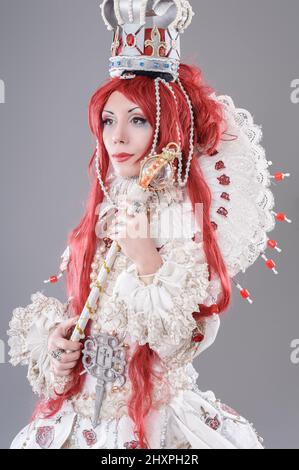 Queen wizard. Model dressed in renaissance style on gray background Stock Photo