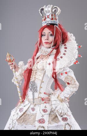 Queen wizard. Model dressed in renaissance style on gray background Stock Photo