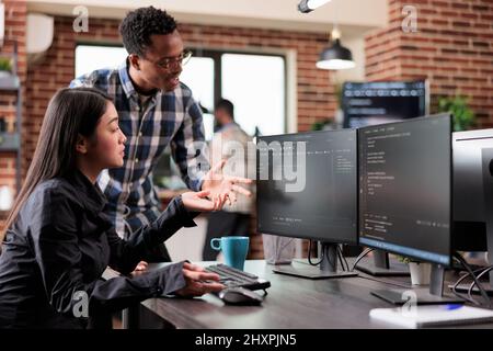 Multiethnic cyber security team developing software algorithm for information processing and network optimization. Informational agency multiracial tech enginners programming application while using computer. Stock Photo