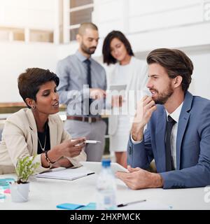 Brainstorming some bright ideas. Shot of businesspeople using digital tablets in an office meeting. Stock Photo