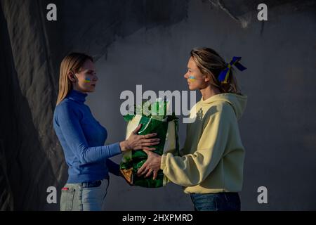 Ukrainian women pacing the bag of groceries one to another Stock Photo