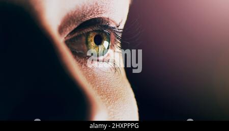 Endless possibilities lie ahead. Closeup shot of man opening his eyes against a dark background. Stock Photo