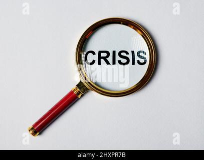 Crisis reasons. Word through magnifying lens. photo Stock Photo