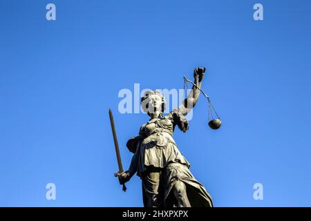 Justitia - Lady Justice sculpture on the Roemerberg square under blue sky Stock Photo