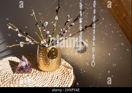 Selective focus on round ball shape crystal rainbow maker suncatcher hanging in home with Orgonite or Orgone pyramid. Good Feng Shui, Sha Chi. Stock Photo