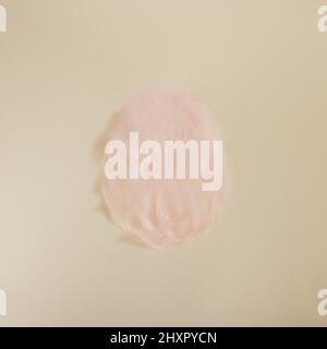 Easter egg shape made from pastel pink feathers on beige minimal background Stock Photo