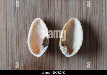 Top view of two empty pistachio shells on wood background Stock Photo