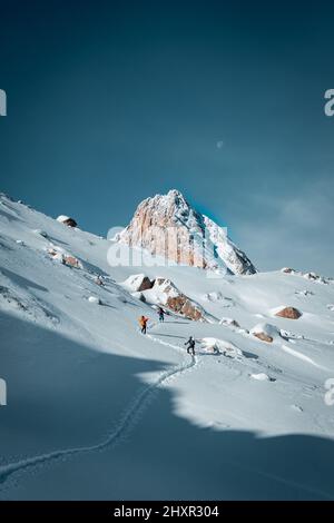 Vertical photo of people skiing in snowy mountains Stock Photo