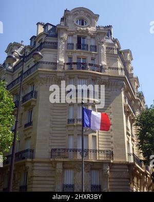 The national flag of France, the Tricolour, flying on a street corner in Paris, France. Stock Photo