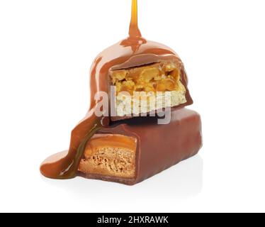 Pouring caramel on broken chocolate bars on white background close-up Stock Photo