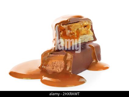 Pouring caramel on broken chocolate bars on white background close-up Stock Photo