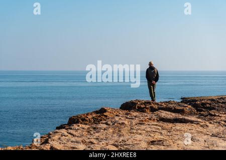 Man on the coast next to Playa de los Locos in the coastal town of Torrevieja in Spain Stock Photo