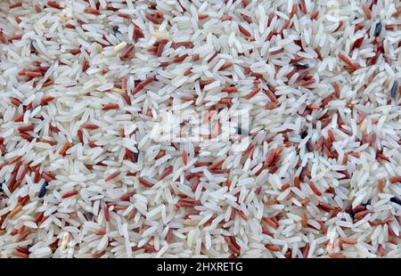 Cuisine and Food, Pile of Uncooked Brown and White Jasmine Long Rice, Basmati Rice or Thai Jasmine Rice. High in Vitamin B3, B6, B1 and B5. Stock Photo