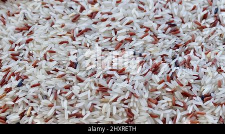 Cuisine and Food, Pile of Uncooked Brown and White Jasmine Long Rice, Basmati Rice or Thai Jasmine Rice. High in Vitamin B3, B6, B1 and B5. Stock Photo