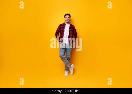Portrait of happy young man posing at yellow studio Stock Photo
