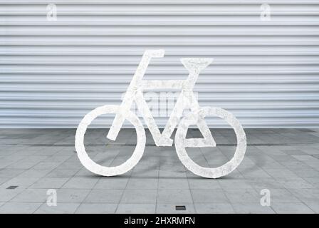 White bicycle sign on asphalt bike cycling Concrete cement floor white stripped garage door background. Stock Photo