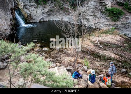 Family resting at Paradise Falls waterfall in Wildwood Park, Conejo Open Space recreation area near Thousand Oaks, California. A popular hiking trail. Stock Photo