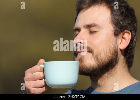 Close up portrait of a man smelling coffee aroma outdoors Stock Photo