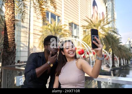 Smiling mutiehnic friends taking a selfie in the street Stock Photo