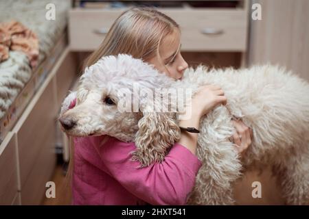 Teenager girl and a big dog - royal poodle. Stock Photo