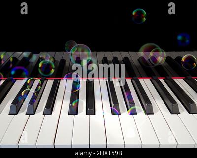 Floating iridescent bubbles on a piano keyboard Stock Photo