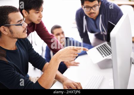 Working hard on a brand new design. Cropped shot of a handsome young man working on his laptop in an office. Stock Photo