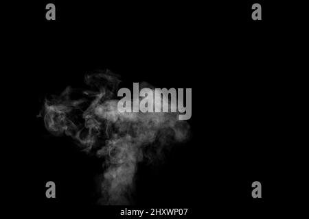 Curly white steam rising up isolated on a black background. Evaporation of liquid and condensation. Can be used as background, design element Stock Photo