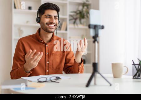 Arab man having videocall using cellphone on tripod Stock Photo