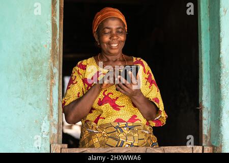 Smiling elderly African woman using her mobile phone Stock Photo