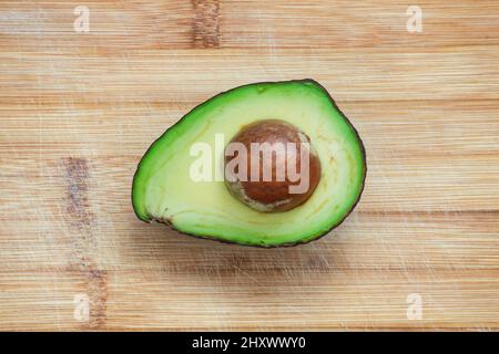 Sliced avocado on wooden background. Top view on ripe avocado. Stock Photo