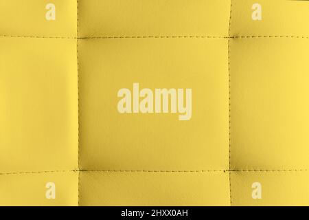 Yellow leather texture background. Detailed background of soft furniture leather or leatherette surface. Stitch pattern. Stock Photo