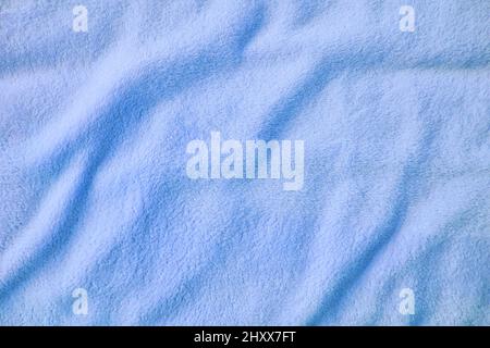 Fluffy gentle pastel blue fabric with waves and folds. Soft pastel textile texture. Abstract background. Stock Photo