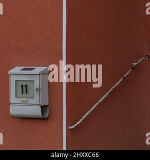 Mailbox on a brick wall with house number '11' Stock Photo