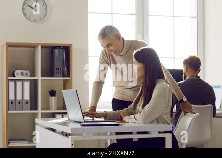 Diverse employees brainstorm work on computer in office Stock Photo