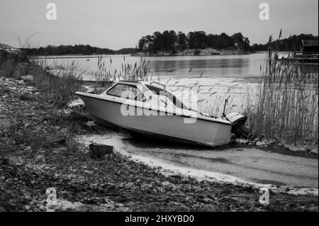 Beautiful shot of an old boat on a coast - in grayscale Stock Photo