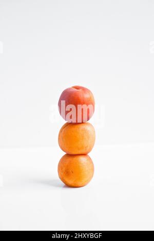 Vertical shot of nectarines in stack on a white background Stock Photo