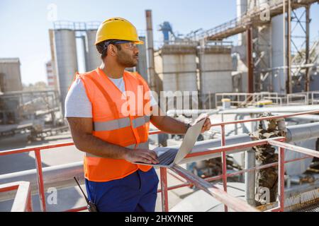 Young worker dressed in safety equipment inside factory Stock Photo