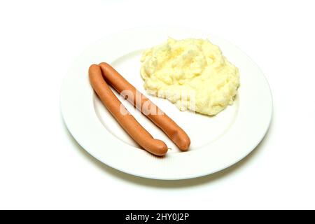 The simple, cheap and fast dish, the couple of wieners with mashed potatoes. Isolated in a white background. Stock Photo