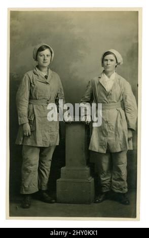 WW1 era very clear, postcard of 2 female munitions friends and workers wearing uniform, trousers, caps. The women are possibly Grinding (milling) House Girls working at HM Factory Langwith. The women here worked in dangerous conditions to produce a chemical called ammonium perchlorate which was mainly used in sea mines, laid by the navy to stop German U-boats from attacking merchant ships bringing vital food and supplies to Britain. Photo from the studio of J H Waterhouse, Chesterfield, Derbyshire, England, U.K. Circa 1917, 1918. Stock Photo