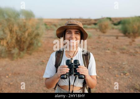 Middle age happy male browsing mobile phone and smiling while relaxing on sofa with pillows near window with curtains Stock Photo