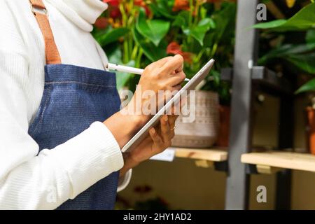 Serious bearded Hispanic male in elegant wear with backpack looking up while standing on railroad station while waiting for train Stock Photo