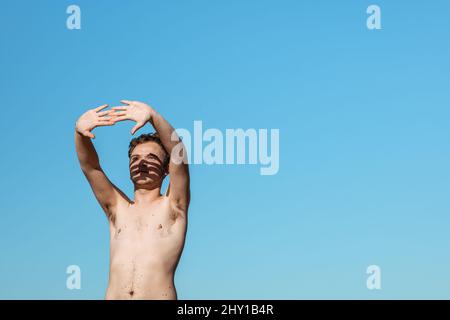 Young male freelancer typing on modern netbook while standing on street in city during online work Stock Photo