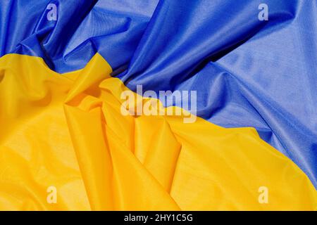 Background full frame of colorful national Ukrainian flag with creased fabric and bright blue with yellow colors placed on surface Stock Photo