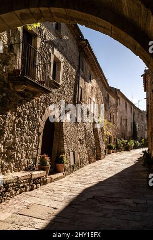 Ancient stone building with rough shabby walls and green plants on sunny day in Spain Stock Photo